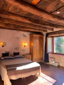 a bedroom with a large bed in a room with wooden ceilings at Casa Rural Ecológica Kaaño Etxea el Bosque y la Naturaleza Sentir in Arrarats