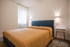 a bedroom with a bed with a blue headboard and a window at Anise Suites in Lovero Valtellino