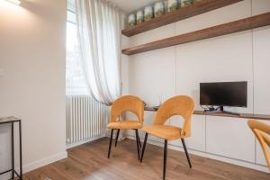 a dining room with two chairs and a television at Anise Suites in Lovero Valtellino