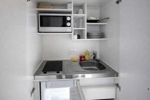 a small kitchen with a sink and a microwave at Kleine Wohnung für Singles in Daun