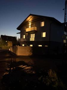a house lit up at night with its lights on at Apartments Javor in Veľký Slavkov