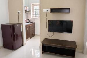 a kitchen with a black refrigerator and a table at Prakash Nilayam Studio I - Kondapur in Lingampalli