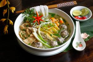 a bowl of soup with meatballs and vegetables on a table at THANH XUAN Hotel in Sapa +16 photos