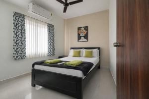 a bedroom with a bed with green pillows and a window at Prakash Nilayam Studio I - Kondapur in Lingampalli