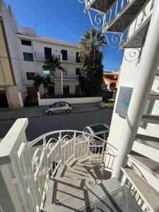 a balcony with a building and a car on a street at Lux Maris in Mazara del Vallo