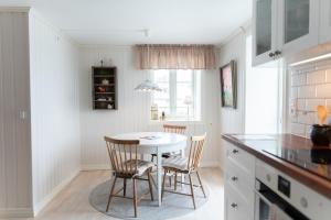 a kitchen with a white table and two chairs at Toftenäs apartment in Toftenäs +20 photos