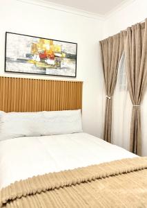 a bedroom with a bed and a painting on the wall at Bonno Stay Suite in Gaborone