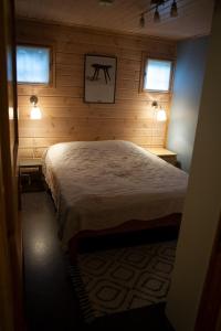 a bedroom with a bed in a wooden wall at Koliwood A in Kolinkylä