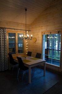 a dining room table with chairs and a chandelier at Koliwood A in Kolinkylä