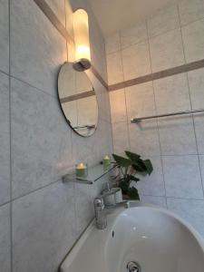 a white bathroom with a sink and a mirror at Ferienwohnung Suter in Seewen