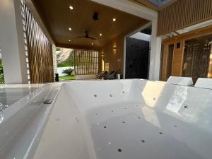 a large white bath tub in a room at ON THE RoCK SEAVIEW in Ban Nua +32 photos