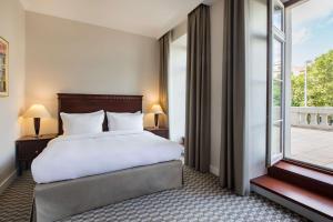 a bedroom with a bed and a large window at Radisson Blu Carlton Hotel, Bratislava in Bratislava