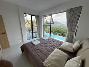 a bedroom with a bed and a large window at ON THE RoCK SEAVIEW in Ban Nua