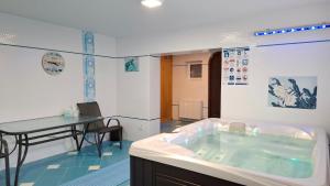 a bath tub in a room with a table and a tableablish at Vila Moldavia Class in Slănic-Moldova