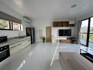 a large white kitchen with a couch and a tv at ON THE RoCK SEAVIEW in Ban Nua