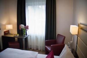 a hotel room with a chair and a window at Hotel Restaurant Passmann in Lüdenscheid