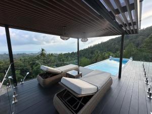 a deck with a couch and chairs next to a pool at ON THE RoCK SEAVIEW in Ban Nua