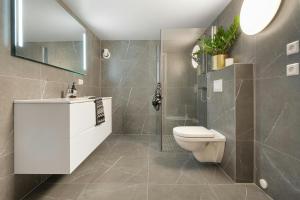 a bathroom with a toilet and a shower and a sink at Hotel Claytone Near Delhi Airport in New Delhi