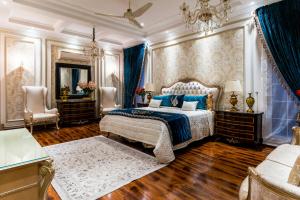 a bedroom with a king sized bed and a chandelier at Hotel Claytone Near Delhi Airport in New Delhi