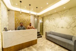 two men standing at a counter in a hotel lobby at La Hotel Metro near BKC in Mumbai