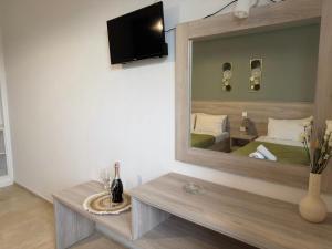 a mirror in a room with a bed and a table at Alex Studios in Laganas