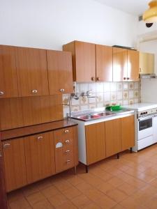 a kitchen with wooden cabinets and a white stove at La Casa di Rossella in Scanno