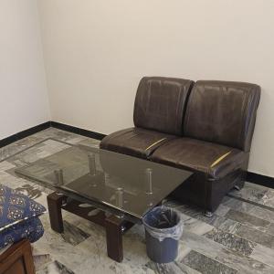 a leather couch and a coffee table in a room at Wali Rest House 1 in Rahimyar Khan