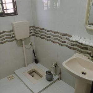a bathroom with a sink and a toilet in the floor at Wali Rest House 1 in Rahimyar Khan