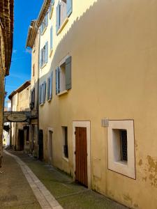 a yellow building with a door on a street at Villa Balma in Beaumes-de-Venise