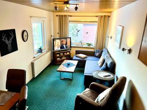 a living room with a couch and a tv at weißer Hirsch im Haus Sabine in Braunlage