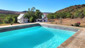a swimming pool in front of a house at Pekárna in Vosburg