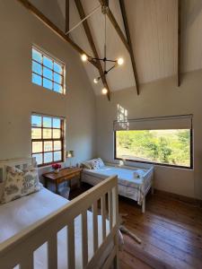 a bedroom with two beds and a large window at Pekárna in Vosburg