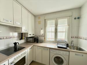 a white kitchen with a sink and a washing machine at La Encarnación in Ávila +7 photos
