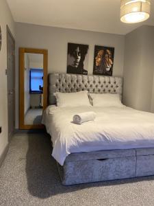 a bedroom with a large bed and a mirror at Marvel Abbeywood, Luxury 3 bedroom House with parking, 2mins walk to Elizabeth Line in Abbey Wood