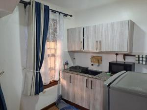 a kitchen with wooden cabinets and a sink and a window at The Ocean Pearl in Diani Beach