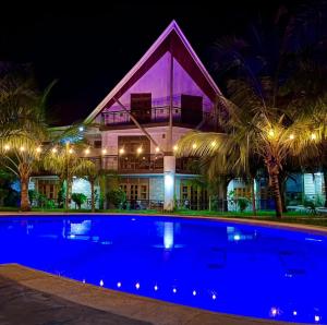 a house with a swimming pool in front of a building at The Ocean Pearl in Diani Beach