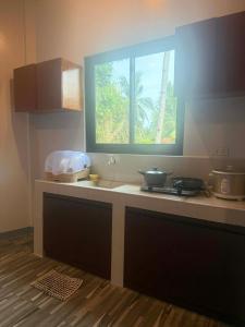 a kitchen with a counter with a window on it at New Apartment in Panglao Island