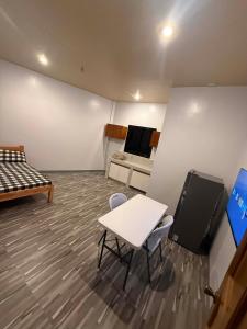 a room with a bed and a table and chairs at New Apartment in Panglao Island +2 photos