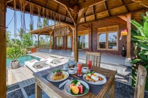 a table with plates of food on top of a house at Atta Villa in Karangasem
