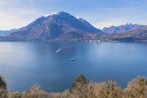 a boat in a large body of water with a mountain at Il Nido sul Lago in Perledo
