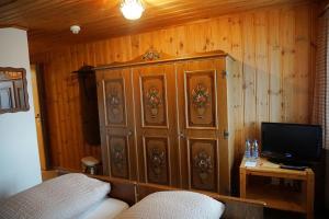 a wooden cabinet in a room with a television at Hotel Tannenboden - Steinbock in Flumserberg