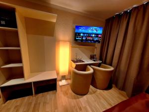 a hotel room with a desk and a tv at Hotel Augustin Komfort Leipzig Ihr Zuhause unterwegs in Leipzig