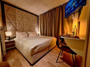 a bedroom with a bed and a desk and a television at Hotel Augustin Komfort Leipzig Ihr Zuhause unterwegs in Leipzig +26 photos