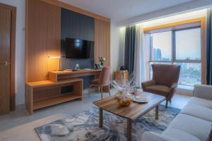 a living room with a television and a table and chairs at Iconic Plaza Hotel in Nairobi