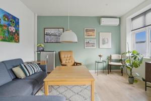 a living room with a blue couch and a table at Apartment in central Holstebro in Holstebro
