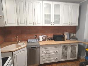 a kitchen with white cabinets and a sink at Apartament Nowogard Centrum - Self Check in - Wejście na KOD in Nowogard