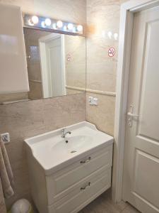 a bathroom with a white sink and a mirror at Apartament Nowogard Centrum - Self Check in - Wejście na KOD in Nowogard +8 photos