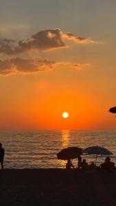 a group of people sitting on the beach watching the sunset at Terra Hélios Suites & Studios in Kyparissia