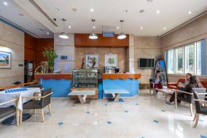 a restaurant with people sitting in a waiting room at Lavender Hotel Sharjah in Sharjah