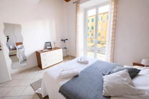 a white bedroom with a bed and a window at Jacuzzi Suite in Livorno